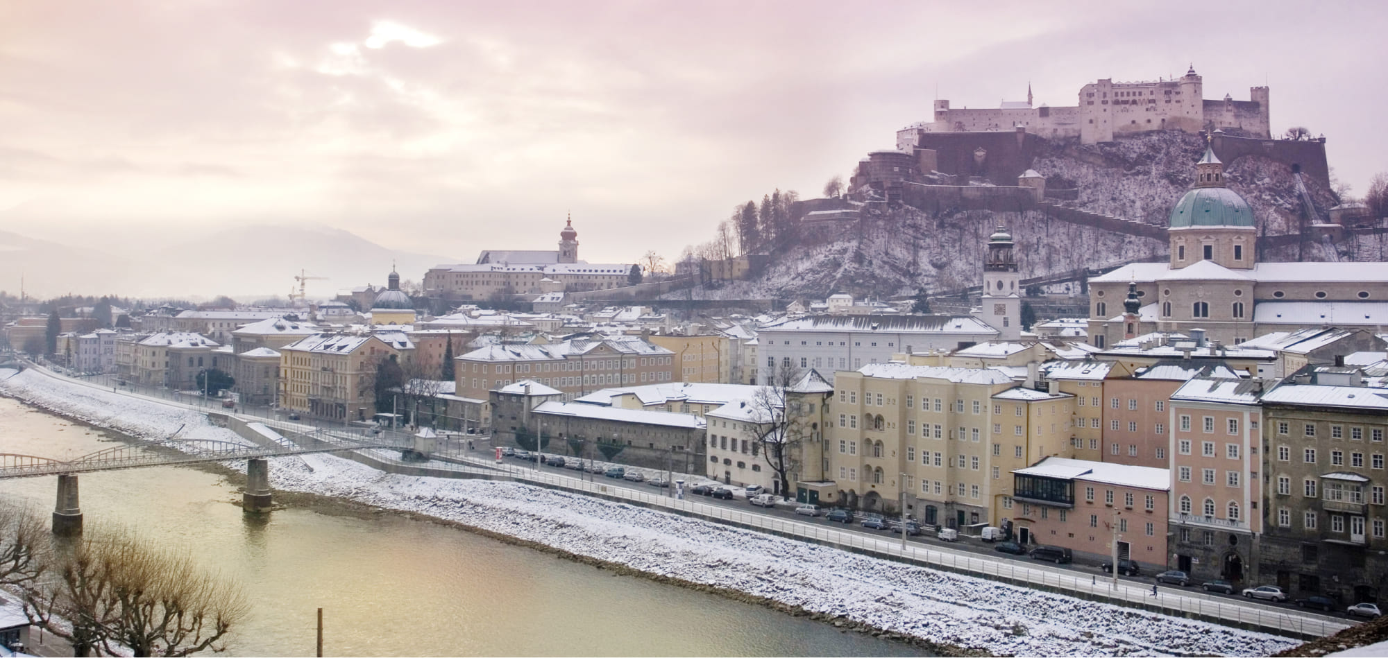 Das winterliche Salzburg mit der Salzach im Vordergrund und der Festung Hohen Salzburg im Hintergrund
